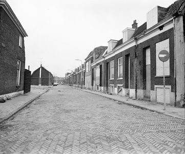 858750 Gezicht op de grotendeels dichtgetimmerde en voor sloop bestemde huizen aan de Riemstraat te Utrecht.